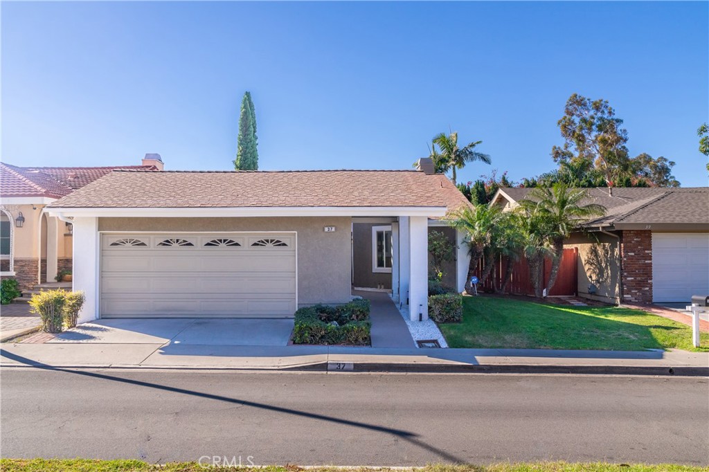 a front view of a house with a garden and plants