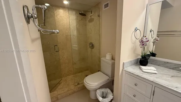 a bathroom with a granite countertop sink toilet and shower