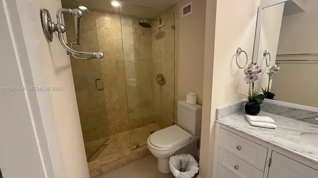 a bathroom with a granite countertop sink toilet and shower
