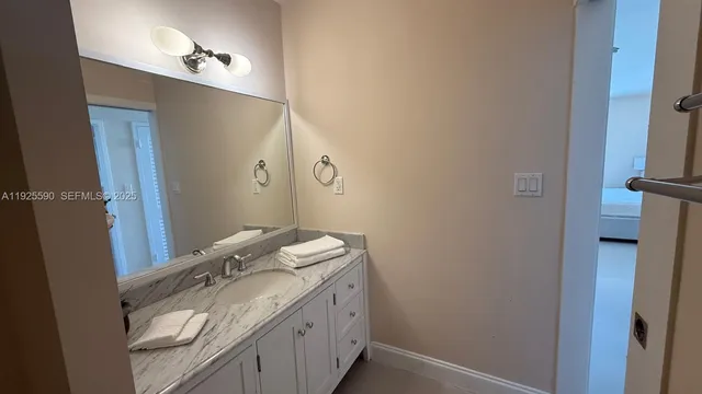 a bathroom with a granite countertop sink and a mirror