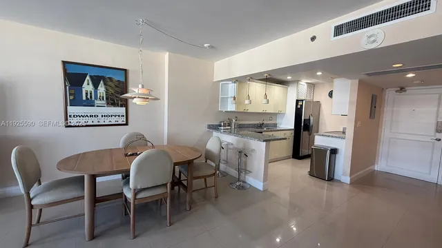 a view of a dining room with furniture and a kitchen