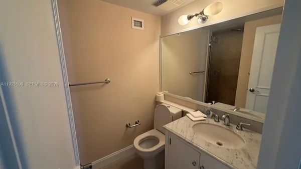 a bathroom with a granite countertop sink toilet and shower a mirror