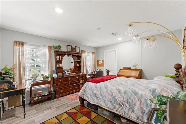 a bedroom with bed and wooden floor