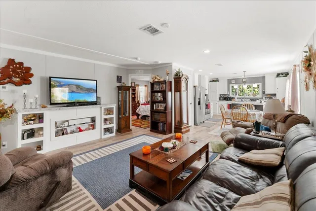 a living room with furniture a flat screen tv and a large window