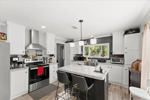 a kitchen with stainless steel appliances a table chairs and a stove