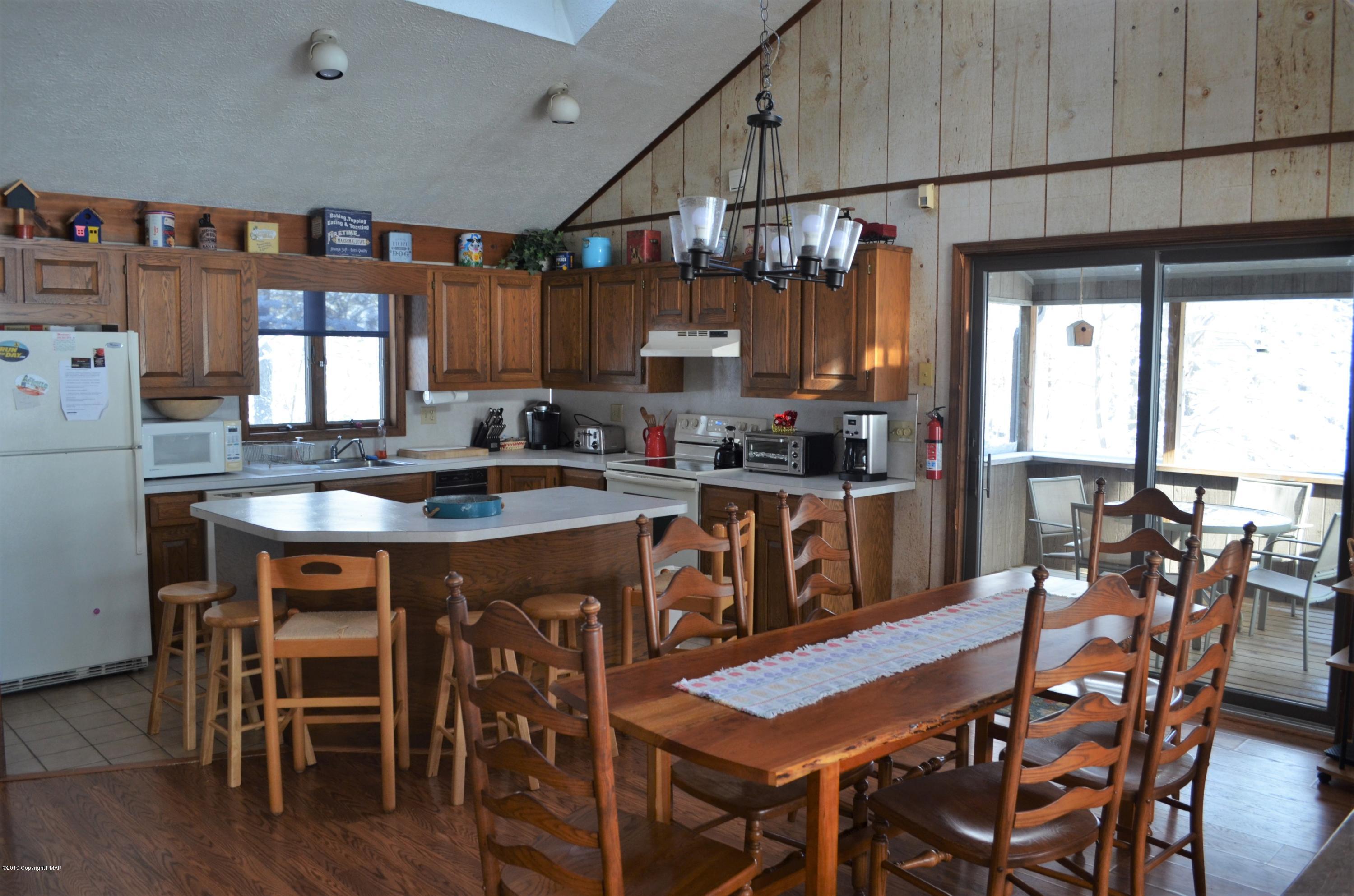 9 Birch Point Road Gouldsboro, PA 18424 - Photo 12 of 41 a kitchen with granite countertop a dining table chairs and white cabinets