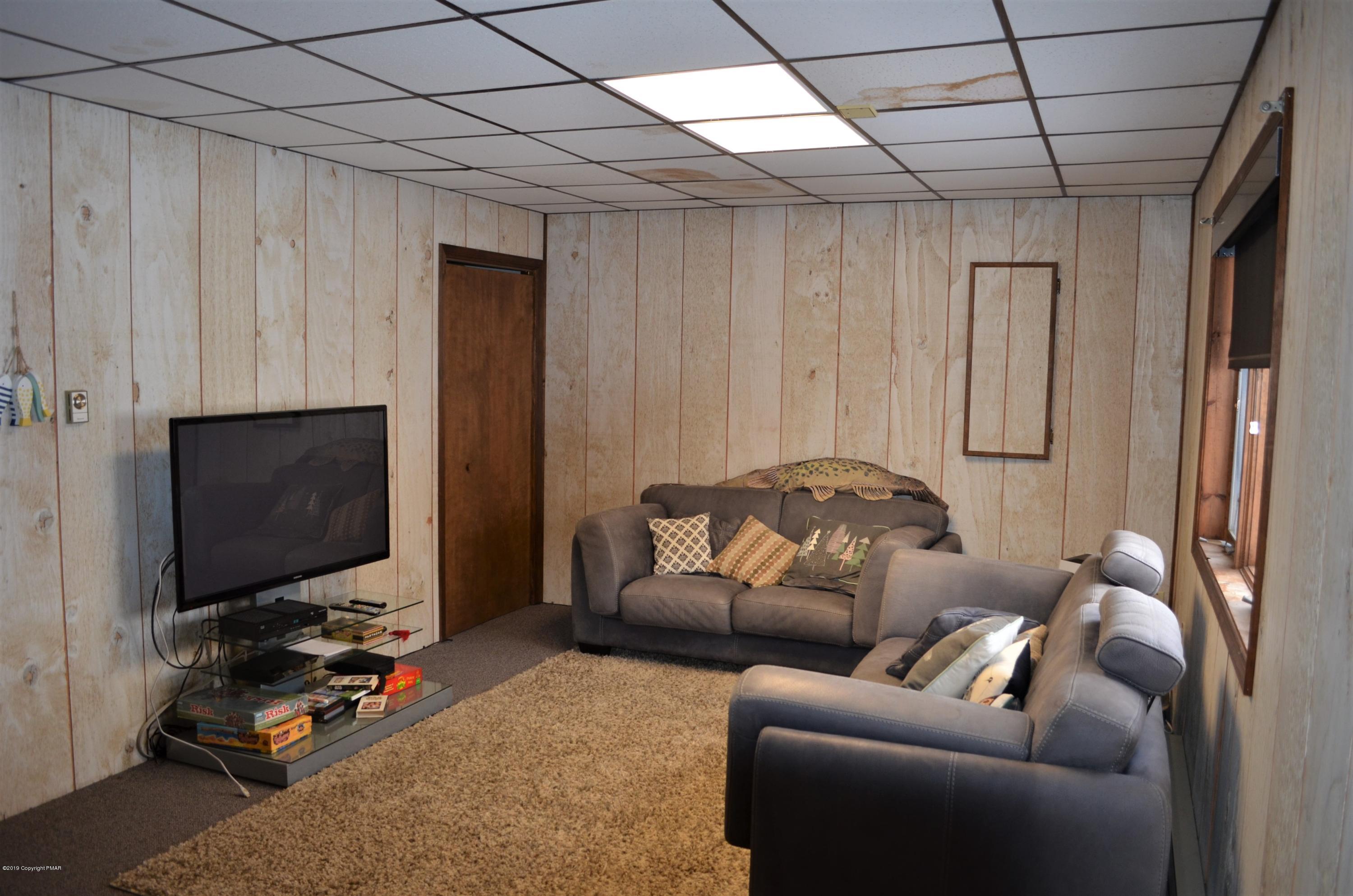 9 Birch Point Road Gouldsboro, PA 18424 - Photo 24 of 41 a living room with furniture a flat screen tv and a window