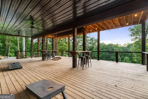a view of a patio with table and chairs potted plants with large tree