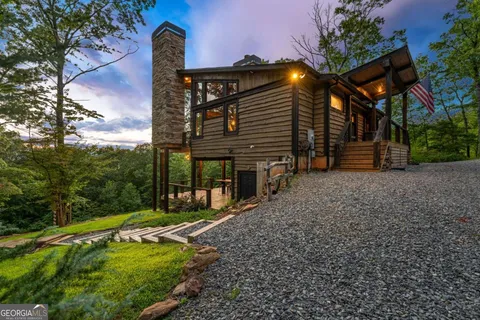 a front view of a house with a yard and potted plants