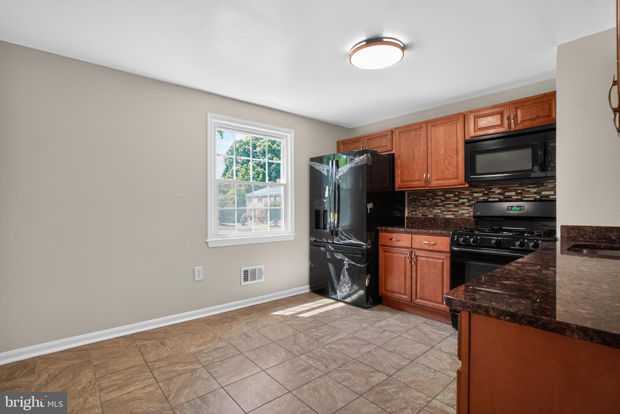 1232 Palmer Road, Unit 111 Fort Washington, MD 20744 - Photo 11 of 45 a kitchen with granite countertop a refrigerator stove top oven and sink