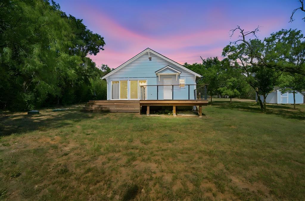 3325 Dove Creek Road Cleburne, TX 76031 - Photo 1 of 40 Light blue siding exterior featuring a natural wood-finish deck with black metal railing