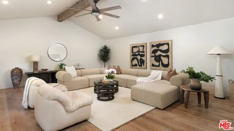 a living room with furniture flowerpot and wooden floor