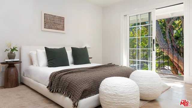 a bedroom with a bed and a large window