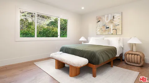 a bedroom with a bed and a painting on the wall