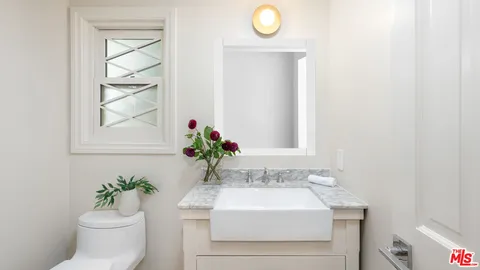 a bathroom with a sink mirror and toilet