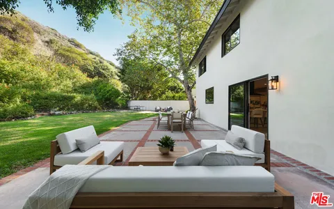 a view of a patio with couches chairs and a yard