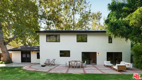 a backyard of a house with table and chairs