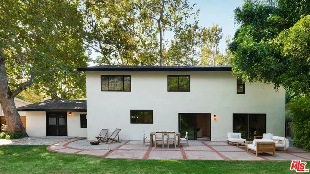 a backyard of a house with table and chairs