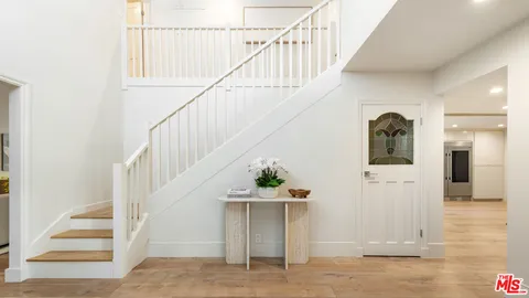 a view of entryway and hall with wooden floor