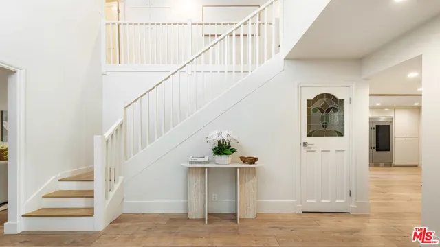 a view of entryway and hall with wooden floor