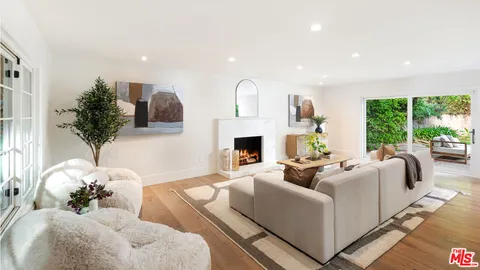 a living room with furniture fireplace and large windows
