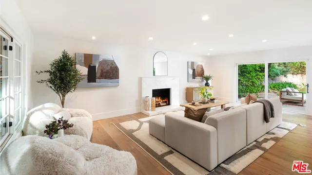 a living room with furniture fireplace and large windows