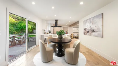 a dining room with furniture wooden floor and a large window