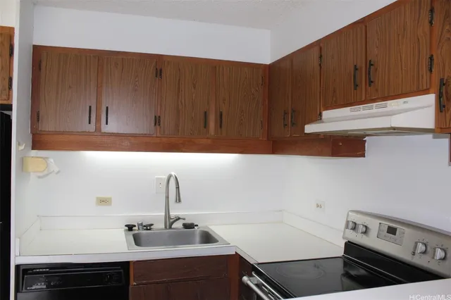 a kitchen with wooden cabinets a sink and a stove