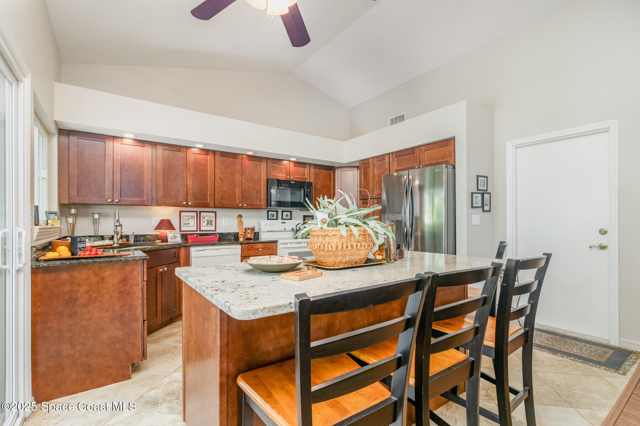 1484 Independence Avenue Melbourne, FL 32940 - Photo 6 of 30 a kitchen with stainless steel appliances kitchen island granite countertop a table chairs sink and cabinets
