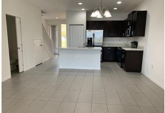 1087 Northwest 33rd Manor Pompano Beach, FL 33064 - Photo 6 of 12 a large kitchen with stainless steel appliances a refrigerator and a stove top oven