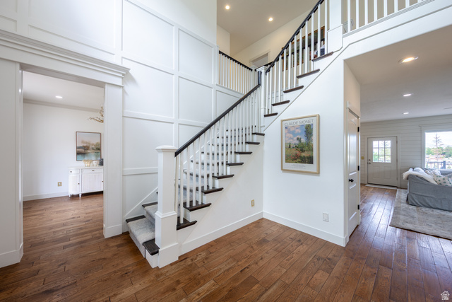 868 Braddock Lane Alpine, UT 84004 - Photo 11 of 64 Two-story foyer featuring wood-finish flooring, a white staircase with dark treads and handrail, and board and batten wall paneling