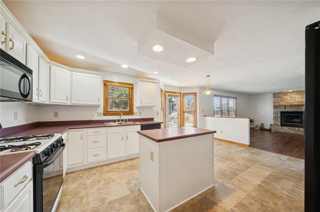 1051 Finchley Road Irwin, PA 15642 - Photo 13 of 36 a kitchen with stainless steel appliances granite countertop a stove top oven a sink a dining table and chairs with wooden floor
