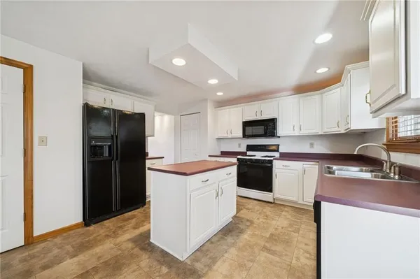 a kitchen with a refrigerator and a stove top oven