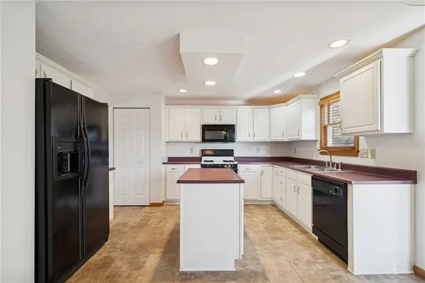 a kitchen with a refrigerator and a stove top oven