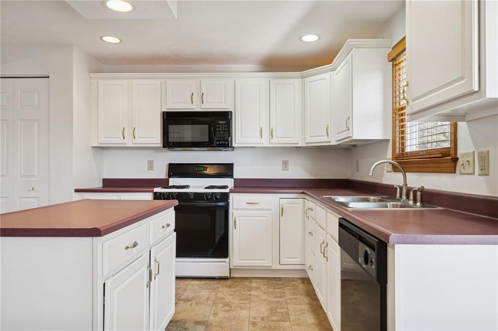 1051 Finchley Road Irwin, PA 15642 - Photo 17 of 36 a kitchen with granite countertop a sink a stove and cabinets