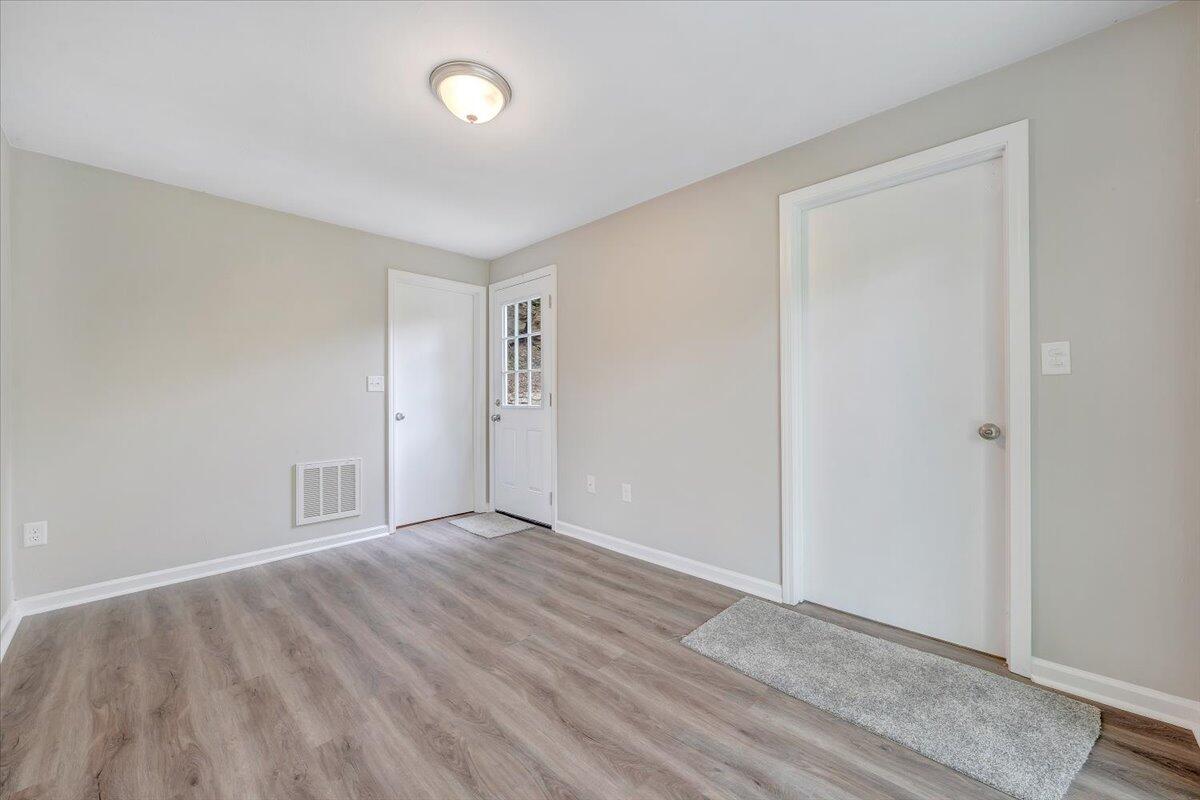 5679 Franklin Road Roanoke, VA 24014 - Photo 5 of 36 a view of an empty room with wooden floor and a window