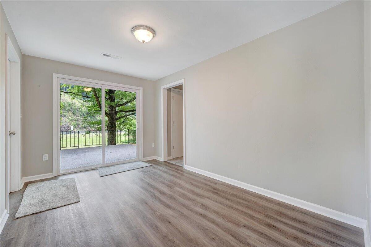 5679 Franklin Road Roanoke, VA 24014 - Photo 6 of 36 a view of an empty room with wooden floor and a window