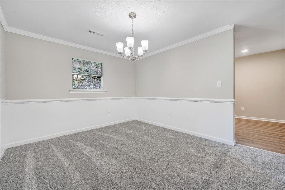 5679 Franklin Road Roanoke, VA 24014 - Photo 10 of 36 an empty room with a chandelier fan and windows