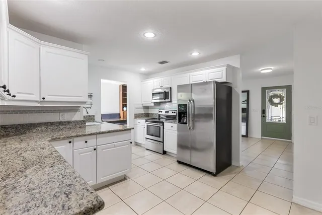 a kitchen with stainless steel appliances granite countertop a refrigerator sink and cabinets