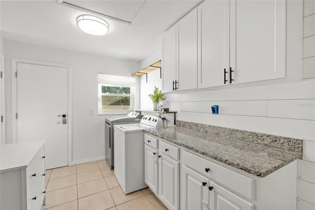 a kitchen with granite countertop white cabinets and sink