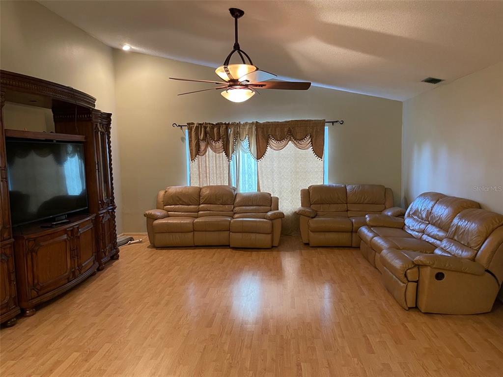 6336 Wooden Street New Port Richey, FL 34653 - Photo 2 of 13 a living room with furniture and a flat screen tv