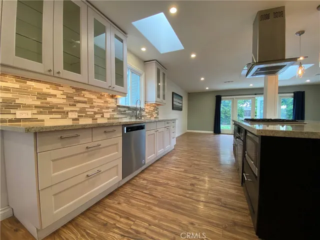 a large kitchen with stainless steel appliances granite countertop a stove and a sink