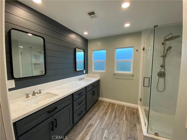 a bathroom with a double vanity sink mirror double and shower