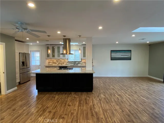 a view of kitchen with kitchen island microwave and wooden floor