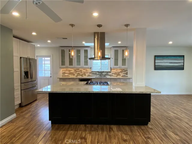 a view of kitchen island wooden floor wooden floor and stainless steel appliances