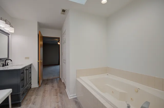 a bathroom with a tub sink and mirror
