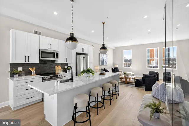 a kitchen with counter space appliances and a view of living room
