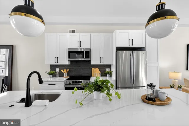 a kitchen with a faucet a stove and white cabinets