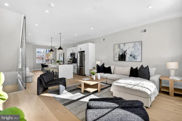 a living room with furniture and a view of kitchen