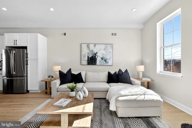 a living room with furniture a refrigerator and a window